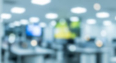 Parlayan ışıklar ve bilgisayar ekranlarıyla bulanık modern ofis içi.