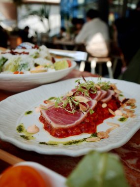 Bitkilerle süslenmiş dilimlenmiş ton balığı bifteği.