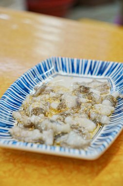 Masada bir tabak çiğ deniz ürünü var.