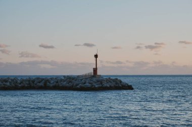 Deniz feneri kayalık iskelede duruyor.