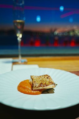 Beyaz tabakta servis edilen gurme yemeği.