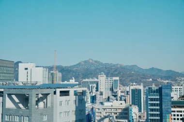 Şehir silueti uzak dağlara bakıyor.