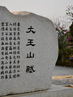 Çinli karakterlerin sergilendiği taş heykel.