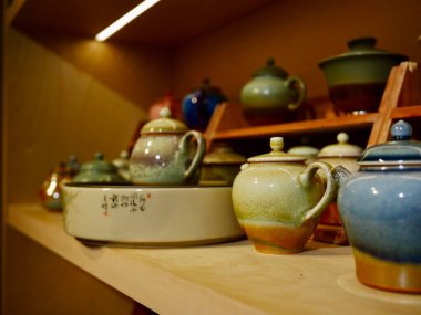 Colorful ceramic teapots displayed on shelves