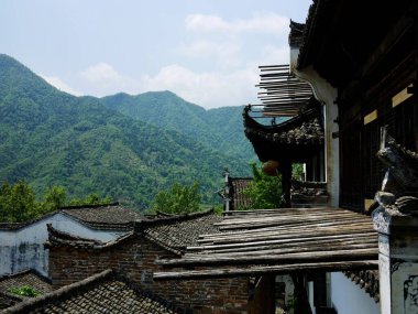 Yeşil dağ manzarasına bakan geleneksel binalar