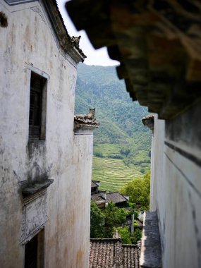 Yeşil dağlara doğru eski binaların arasına bak