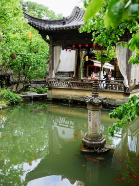 Huzurlu yeşil göletin yanındaki geleneksel pavyon