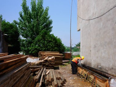 İnşaat alanı yakınlarındaki malzemeleri denetleyen işçiler