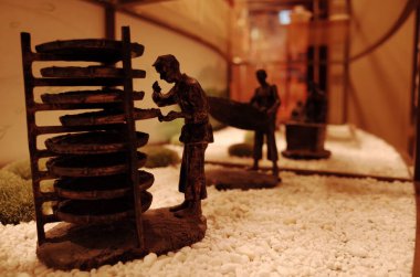 Malzemeleri düzenleyen işçilerin resmedildiği küçük heykeller
