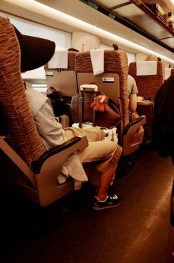 İnsanlar tren kompartımanında oturuyor.