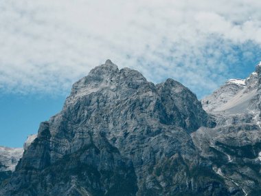 Parlak mavi gökyüzünün altındaki görkemli dağlar
