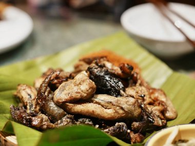 Muz yapraklarında servis edilen lezzetli kızarmış balıklar.