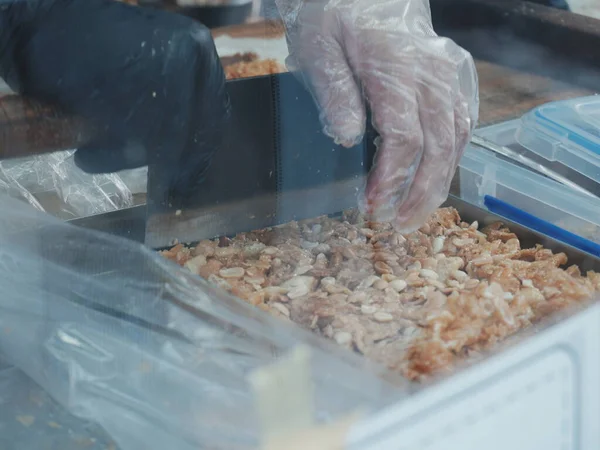 Eller plastik kabın içinde yemek hazırlıyor.