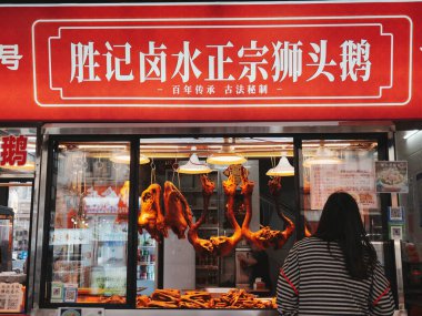 Kadın yemek vitrinine bakıyor.