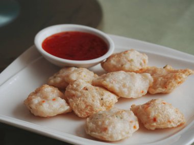 Bir tabak soslu kızarmış hamur köftesi.