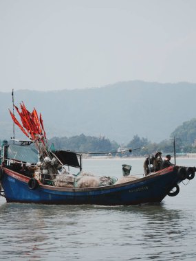 Uzak dağların yakınında yüzen balıkçı teknesi