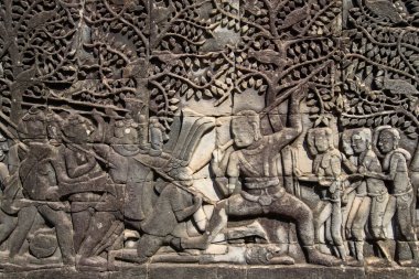 Bayon Tapınağı, Angkor, Kamboçya 'daki taştan kabartmalar, Angkor döneminin kültürel, sosyal ve sanatsal zenginliğini yansıtan Khmer halkının hem askeri faaliyetlerini hem de günlük aktivitelerini tasvir ediyor..