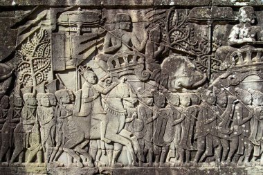 Bayon Tapınağı, Angkor, Kamboçya 'daki taştan kabartmalar, Angkor döneminin kültürel, sosyal ve sanatsal zenginliğini yansıtan Khmer halkının hem askeri faaliyetlerini hem de günlük aktivitelerini tasvir ediyor..
