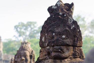 Bayon Tapınağı 'ndaki Naga taş köprüsünde, Angkor Thom, Hindu mitolojisini sembolize eden ve zarif Khmer taş oymalarını sergileyen koruyucu tanrılar ve iblisler vardır..