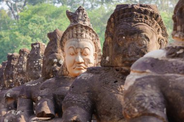 Bayon Tapınağı 'ndaki Naga taş köprüsünde, Angkor Thom, Hindu mitolojisini sembolize eden ve zarif Khmer taş oymalarını sergileyen koruyucu tanrılar ve iblisler vardır..
