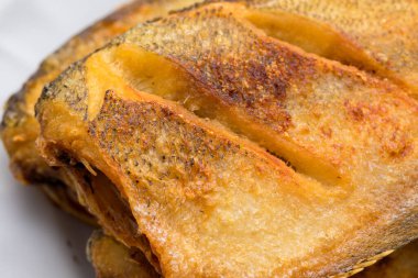 Thai-style fried snakeskin gourami served on a plate, showing crispy golden-brown skin and appetizing texture.