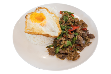 Popüler Tayland sokak yemekleri. Kutsal fesleğenle kızartılmış biftek. Çeşnili yumurta ile pilav üzeri servis ediliyor. Şeffaf arka planda izole edilmiş..