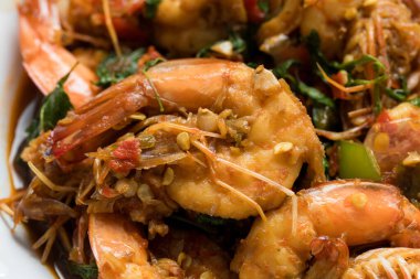 Tayland usulü fesleğenli kızarmış karides, canlı renkler, parlak fesleğen sosu ve Tayland yemeği sunumu, restoran menüleri, yemek servisi ve ticari kullanım için uygun iştah açıcı doku..