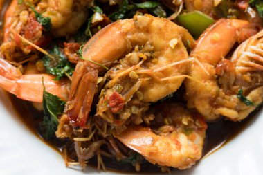 Tayland usulü fesleğenli kızarmış karides, canlı renkler, parlak fesleğen sosu ve Tayland yemeği sunumu, restoran menüleri, yemek servisi ve ticari kullanım için uygun iştah açıcı doku..