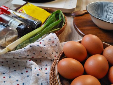 Asya mutfağı için malzemeler: yumurta, scallion, soya sosu. Parlak, doğal ışıklandırma. Ahşap masaya dizilmiş yemek malzemelerini yakından çek. Sığ alan derinliği, sıcak tonlar ve....