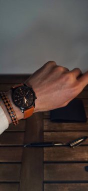 Premium saat sergileyen bir erkek elin minimal yakın çekimi. Parlak profesyonel ışıklandırma, kopyalama alanı ile iş kullanımı için mükemmel.