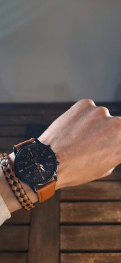 Klasik erkek eli, lüks kronograf saat ve deri aksesuarlar takıyor. Kopya alanı ile temiz stüdyo ışıklandırması.