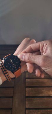 Lüks bir kol saatinin zamanını ayarlayan işadamlarının yakınına. Metin için profesyonel ışıklandırma ve boşluk ile parlak beyaz arkaplan.