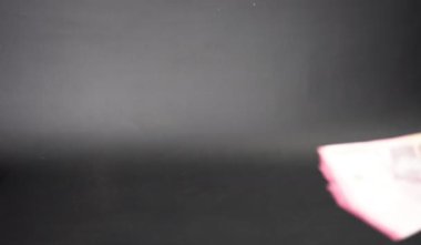 Bir adamın bir kadına yüz bin rupiah vermesi, maaş verme konsepti, THR tatil parası, rüşvet, para, siyah arka planda izole edilmiş.