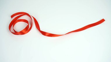 Kırmızı kurdele beyaz arkaplanda eğri büğrü yatıyor