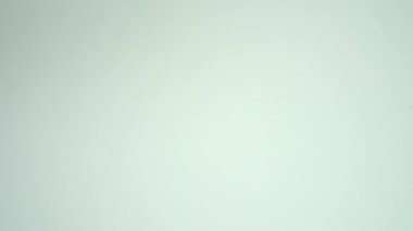 Bir kadının eli pembe bir kurdele tutuyor. Beyaz bir arkaplanda, göğüs kanserine karşı farkındalığı ve desteği simgeliyor..