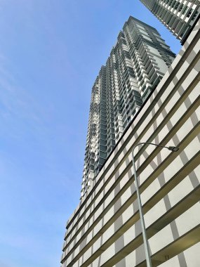 Geometrik cephesi ve berrak mavi gökyüzü olan yüksek binaların alçak açılı görüntüsü