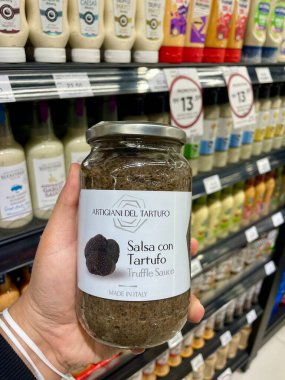 Kuala Lumpur - 8 Aralık 2025 Artigiani del Tartufo Mantar Sosu kavanozu İtalyan markası ile market koridorunda tutuluyor.