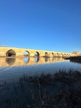 Mimari dönüm noktası gündüz fotoğraflandı, durgun suda klasik duvarcılık detaylarını gösteriyor..