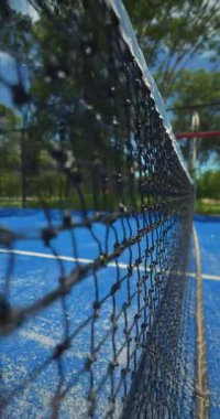 Ön planda tenis ağı, mavi kort ve odak dışı arka plan