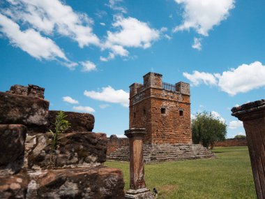 Açık bir ortamda, mavi gökyüzü ve bulutları olan tarihi tuğla ve taş şeklindeki bina. Mimarlık, miras, tarih, turizm, seyahat ve anıtlar için ideal.