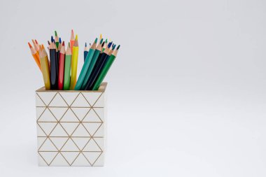 Beyaz bir arka planda izole edilmiş kalem tutacağına yerleştirilmiş parlak renkli kalemler. Yüksek kontrastlı ve kopyalama alanı olan en temiz kompozisyon. Yaratıcılık kavramı, eğitim, ofis malzemeleri ve okula dönüş.
