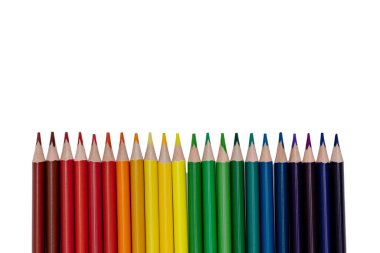 Alttaki gökkuşağı gradyan çizgisinde, temiz beyaz arka planda izole edilmiş renkli kırpılmış kalemler. Canlı spektrum renkleri, minimal bileşimi ve metin için kopyalama alanı olan okul kavramına yaratıcı dönüş.