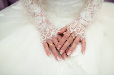 Gelin ve damat bir alyans tutuyor.