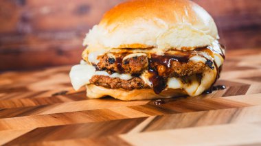Tahtada peynirli ve pastırmalı ev yapımı hamburger.