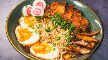 fried noodles with pork, egg, vegetables and sauce on plate