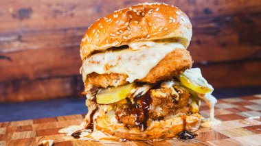 Ahşap masada ızgara tavuk ve hamburger.