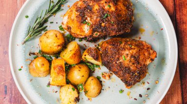 Lezzetli ovalarla kaplanmış kızarmış tavuk budu, fırında altın patates ve taze biberiye ile güzel bir tabak. Sulu, çıtır çıtır ve doyurucu yemekler aile yemekleri ve toplantılar için mükemmel..