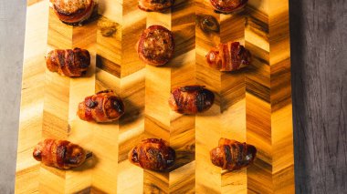 Sosisli börek ve domuz pastırmalı turlar, paylaşım için güzelce düzenlenmiş. Partiler, tatiller ve lezzetli parmak yiyecekleri olan misafirler için mükemmel..