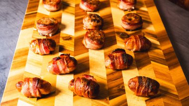 Sosisli börek ve domuz pastırmalı turlar, paylaşım için güzelce düzenlenmiş. Partiler, tatiller ve lezzetli parmak yiyecekleri olan misafirler için mükemmel..