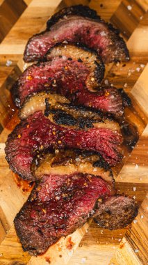 Az pişmiş göğüs eti, kavrulma kaynaklı koyu, çıtır çıtır bir ovalama, ahşap bir tahtaya güzelce yerleştirilmiş. Yumuşak pembe iç kabuk, et severler ve gurme sunumu için mükemmel..